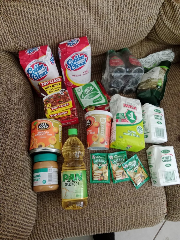 Donation of staple groceries including pasta, sugar, and maize meal
